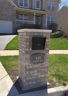 a brick mailbox sitting in front of a house