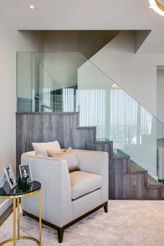 a living room with a chair, table and stairs