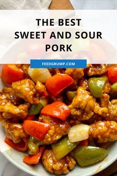 the best sweet and sour pork with peppers in a white bowl on a wooden table