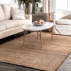 a living room with two couches, a coffee table and a rug on the floor