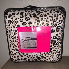 a leopard print suitcase with a pink tag on it