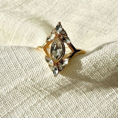 a gold ring sitting on top of a white cloth covered in diamonds and other jewels