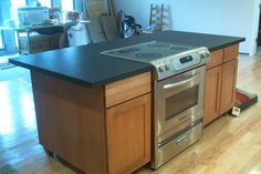 a kitchen island with an oven in the middle and a stove top on the other side