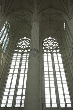 two large windows in the middle of a building with columns and arches on each side