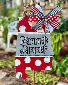 a red and white polka dot sign with a bow hanging from it's side