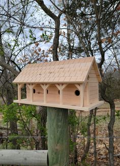 a wooden bird house on top of a pole