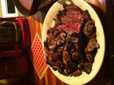 steak and mushrooms on a plate next to an air fryer