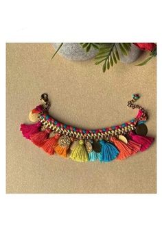 a multicolored necklace with buttons and tassels hanging from it's side