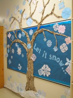 a bulletin board decorated with snowflakes and a tree