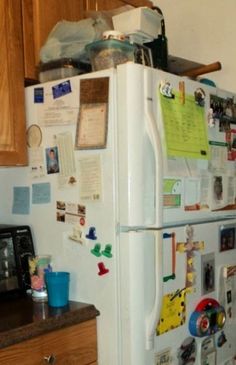 a refrigerator covered in magnets and papers