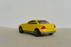 a yellow toy car sitting on top of a table