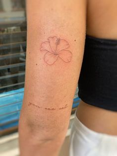 a woman's arm with a flower tattoo on the left side of her arm