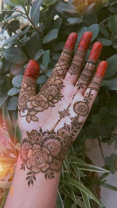 a woman's hand with henna on it and flowers around the palm area