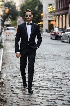 a man in a tuxedo is walking down the street