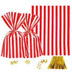 two red and white striped bags with gold foil decorations next to each other on a white background