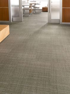 an office with carpeted floors and wooden cabinets