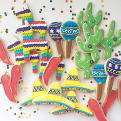 decorated cookies are arranged on a table with confetti