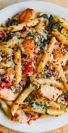 a white plate topped with pasta and chicken