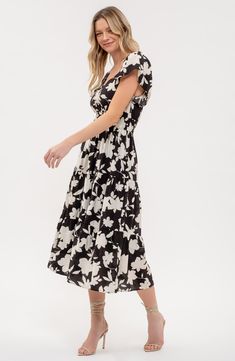 A garden of flowers bloom upon a midi dress designed in a tiered silhouette. 48 1/2" length Slips on over head Sweetheart neck Short sleeves Lined 82% rayon, 18% nylon Hand wash, dry flat Imported Printed Tiered Midi Dress For Spring, Tiered Printed Midi Dress For Spring, Black Fitted Tiered Dress For Spring, Tiered Floral Print Midi Sundress, Floral Print Maxi Length Tiered Dress For Brunch, Spring Rayon Dresses With Tiered Skirt, Chic Floral Print Tiered Dress For Garden Party, Elegant Black Tiered Dress For Spring, Flowy Floral Print Tiered Dress For Spring