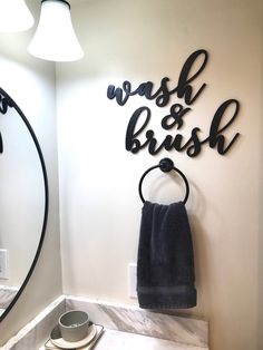 a bathroom with a sink, mirror and towel rack on the wall next to it