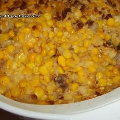 a white crock pot filled with corn and meat