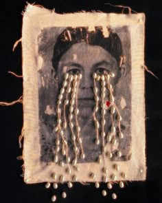 an old photo with pearls and beads on it's face is framed by string