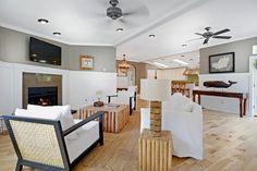 a living room filled with furniture and a flat screen tv mounted to the wall over a fire place