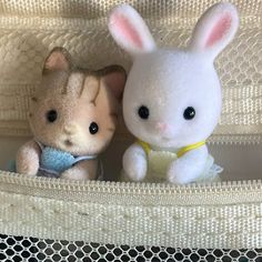 two stuffed animals are sitting in a crib