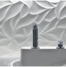 a white sink sitting under a faucet next to a wall covered in wavy paper