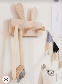 two wooden toys hang on the wall next to a stuffed animal