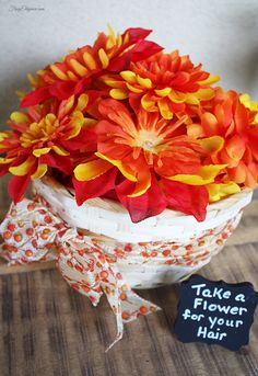 there is a basket with flowers in it and a sign that says take a flower for your hair