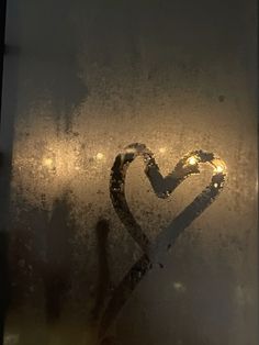 a frosted window with a lighted heart on it