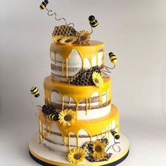 a three tiered cake decorated with sunflowers and honeybees on top