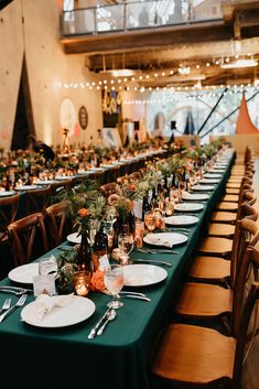 a long table is set up with plates and silverware for an elegant dinner party