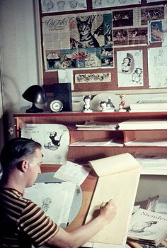 a man sitting at a desk drawing on paper