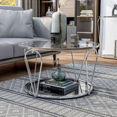 a living room with a couch, coffee table and books on the floor in front of it