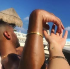 a man and woman sitting next to each other at the beach with their arms around each other