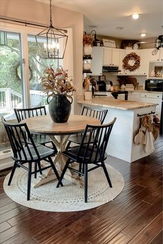 a kitchen table with four chairs and a potted plant on top of the table