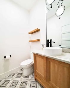 a bathroom with a sink, toilet and mirror