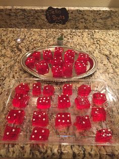 some red dices are sitting on a tray in the middle of a counter top