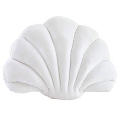 a white shell shaped pillow sitting on top of a table