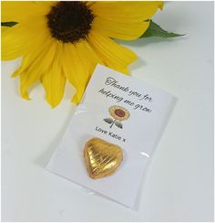 a sunflower and a heart shaped brooch sitting next to each other on a card