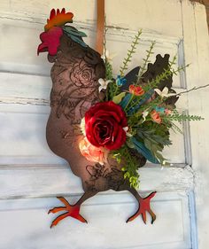 a rooster made out of flowers on the side of a door