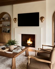 a living room filled with furniture and a fire place next to a wall mounted tv