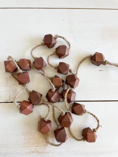 small wooden cubes tied together with twine on a white wood background, top view