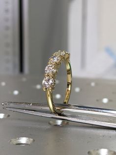 a diamond ring sitting on top of a piece of metal next to a pair of scissors