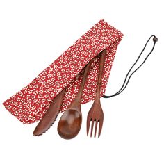 three wooden utensils and a red flowered napkin with white flowers on it