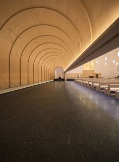 an empty room with benches and lights on the ceiling is shown in this image, it appears to be very large