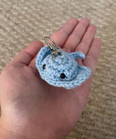 a small crocheted keychain in the palm of someone's hand