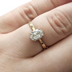 a woman's hand with a diamond ring on top of her finger and an engagement band